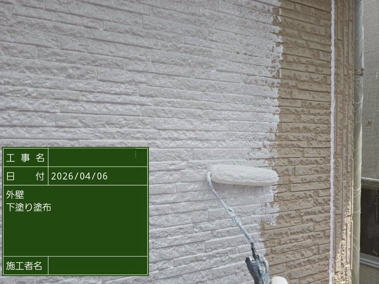 白い下塗り材で塗装中のサイディング外壁